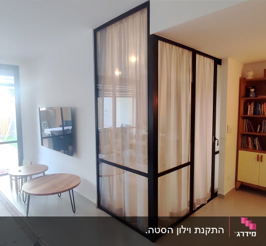 וילון לבן במסגרת מתכת שחורה בחדר פנימי